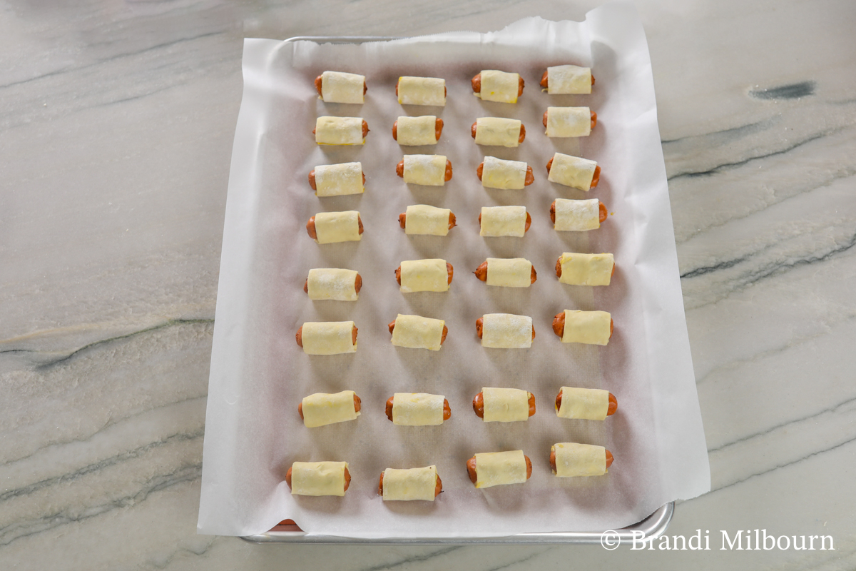 Place pigs in a blanket seam down on silpat/silicone mat covered with parchment paper-covered baking sheet approximately ½ - 1 inch apart.  