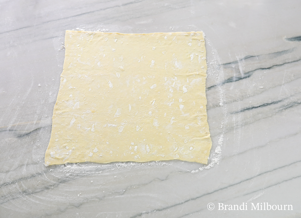 On a floured surface, roll out pastry puff to slightly larger than a 12" x 12" square.