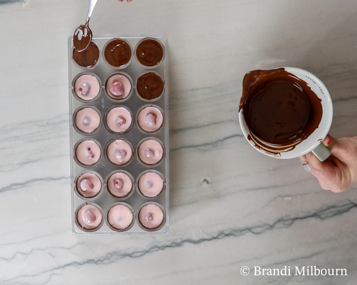 Remove chocolate from oven and stir. 

Cover tops of cherry and fondant to seal the chocolate covered cherry.