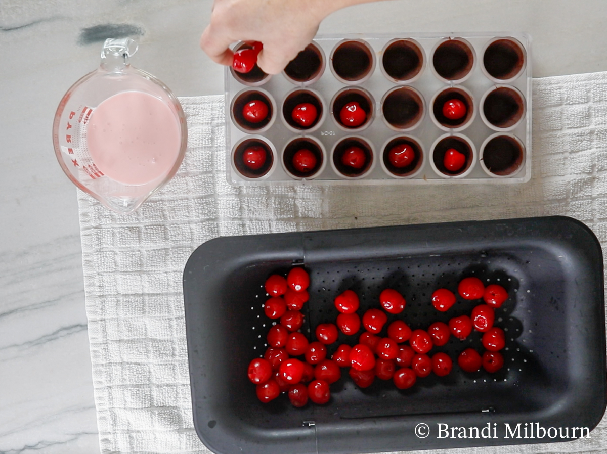 Remove chocolate mold from freezer. 

Place 1 stemless cherry in each mold.