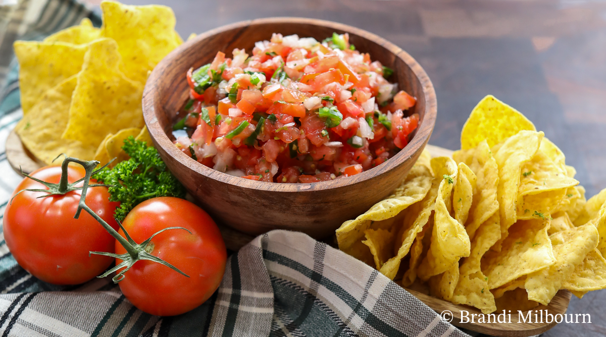 Authentic bowl of pico de gallo with a side serving of chips