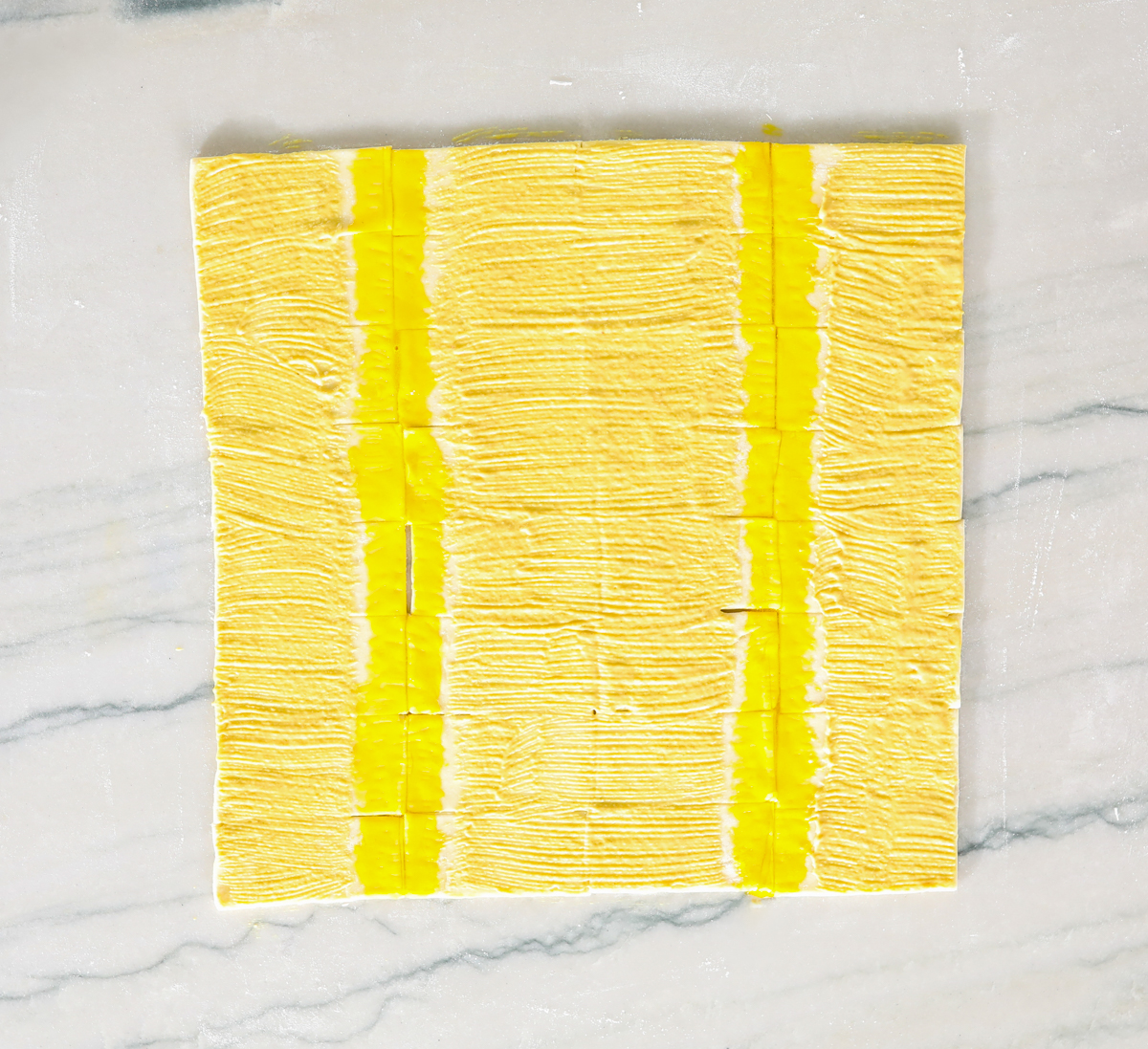 Use pastry brush to paint egg yolk about ½ inch wide down right and left inner cuts (3 inch cut and 9 inch cuts) and skip the inside seam. Brush the remainder of the dough with Dijon mustard.