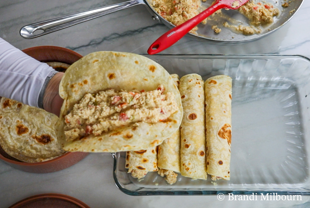 Assemble enchiladas/burritos: Fill each tortilla with approximately ½ cup of filling. Then top with shredded Monterey jack cheese and roll up in a 9x13-inch pan. Place seam side down.