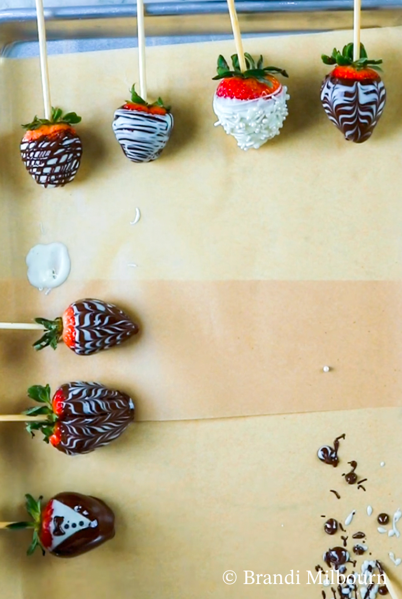 Finished chocolate covered strawberries drying on parchment paper