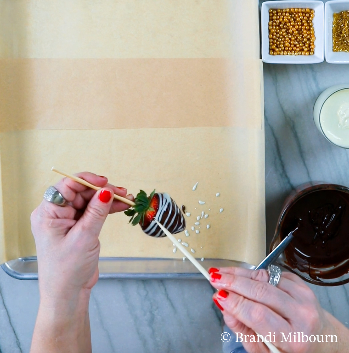 Making chocolate covered strawberry with white chocolate stripes by using a bamboo skewer to make lines