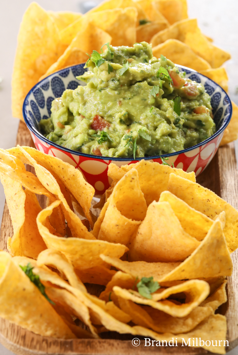 Bowl and guacamole surrounded by chips