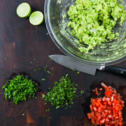 Mashed avocado with chopped vegetables for guacamole