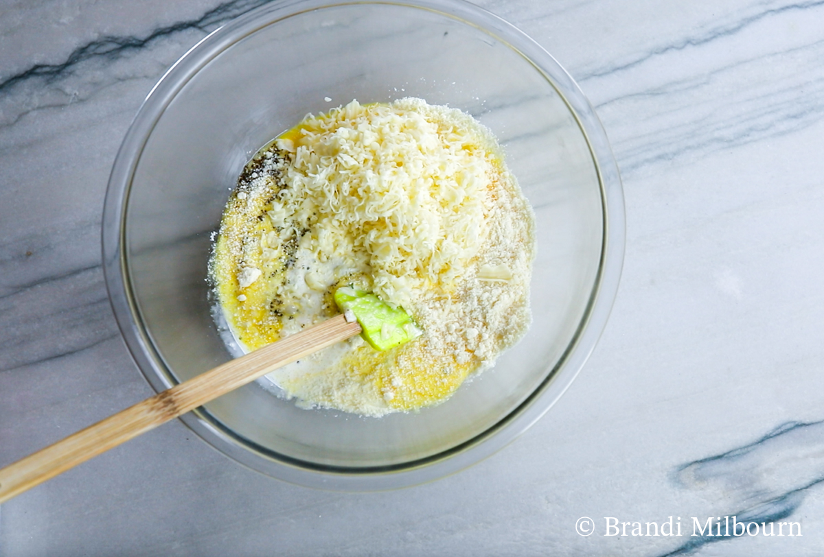 mixing ingredients for crab quiche in medium bowl