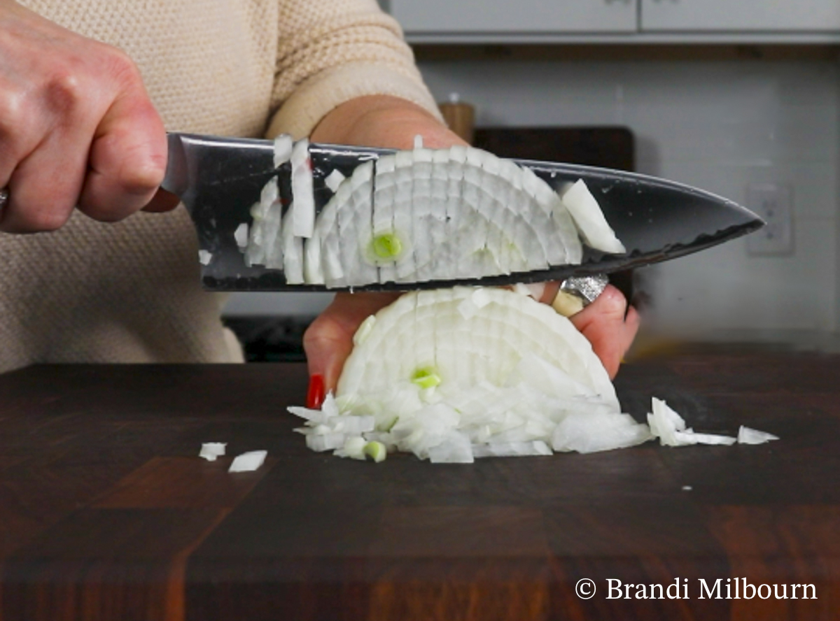 Chopping onion for white chicken chili recipe. White chili recipe with chicken