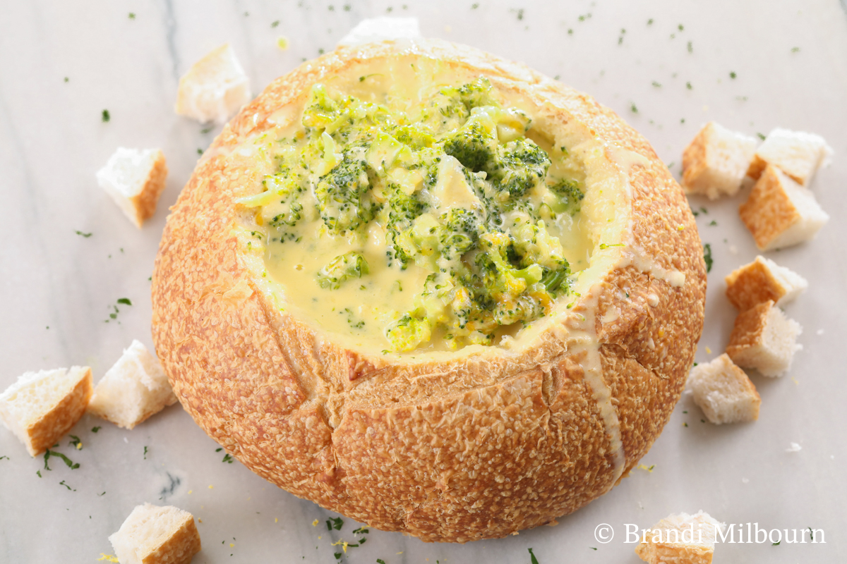 bowl of broccoli cheese soup in a bread bowl that is better than Panera