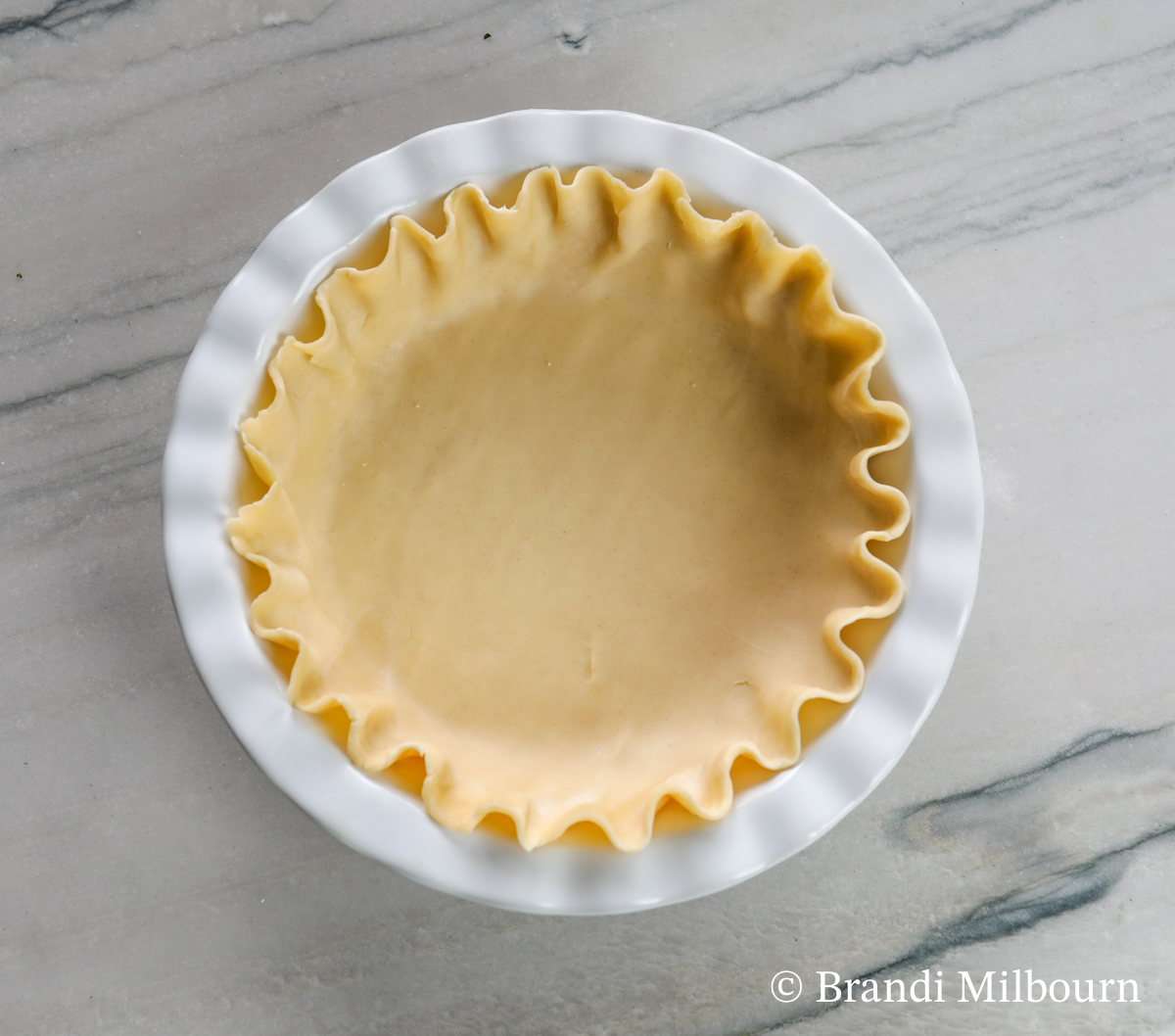 pie crust in 9 inch round pie dish with edges rounded