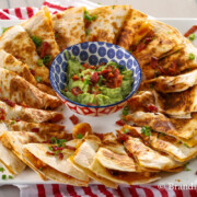 chicken and shrimp quesadillas on a platter with creamy guacamole to dip