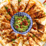 chicken and shrimp quesadillas on a platter with creamy guacamole to dip