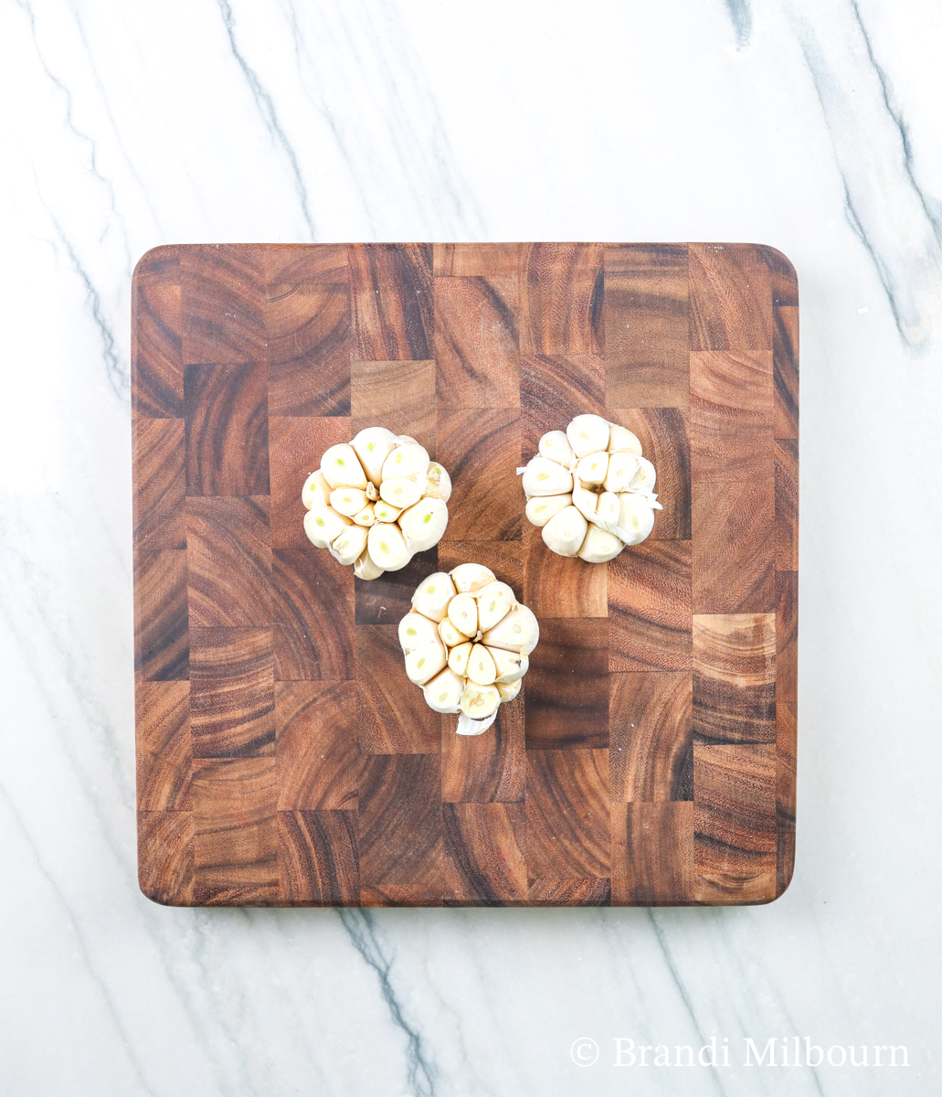 cut and peeled garlic heads on cutting board