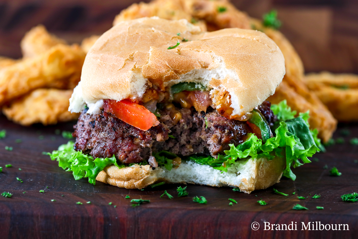 Thick Steakhouse Burger Cooked to Perfection with bite out of the sandwich.